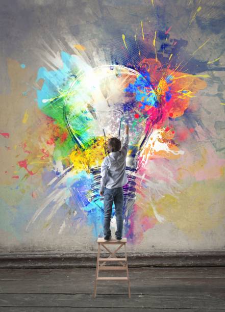 Child stands on the top of a ladder and painting on the wall